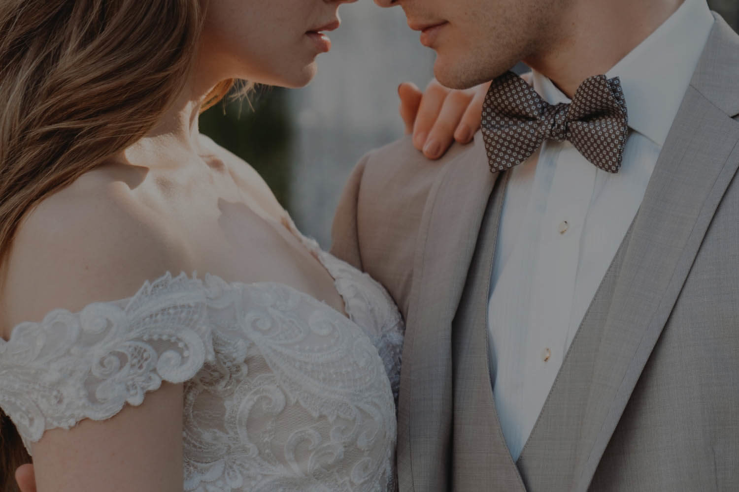 Сouple wearing a white gown and a gray suit. Mobile image
